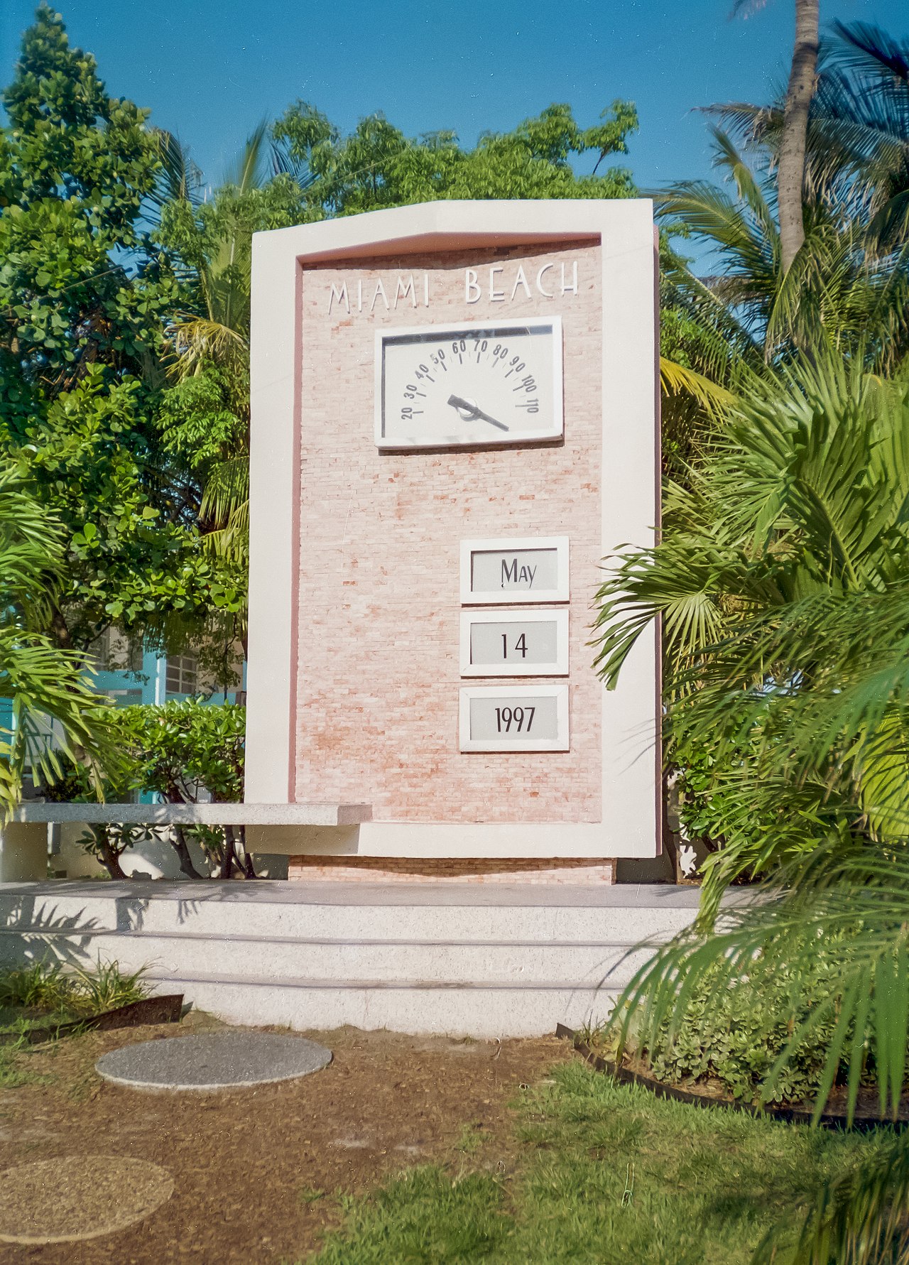 Woman walking along Lummus Park beach in South Beach with pastel Art Deco buildings in background